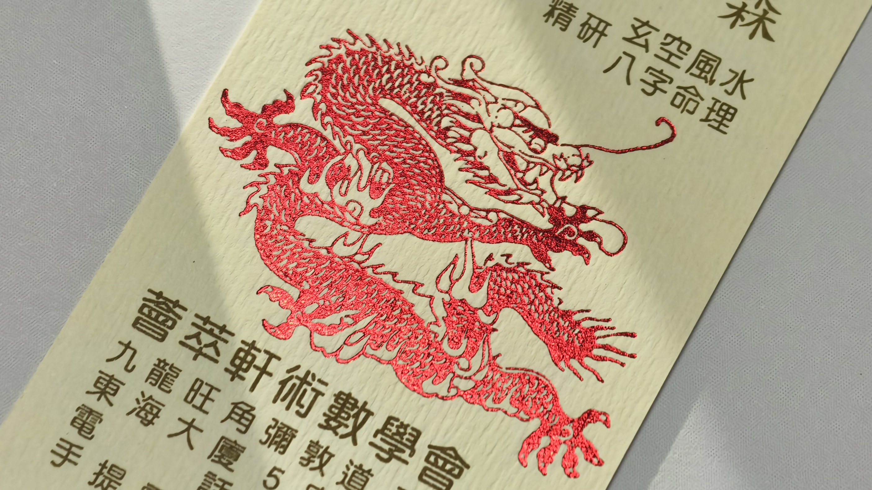 印刷易產品實照:米白色咭片印有紅色燙金龍紋圖案及黑色中文字,紙面帶壓紋質感